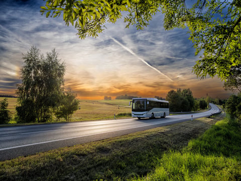 Bus on rural road at sunset